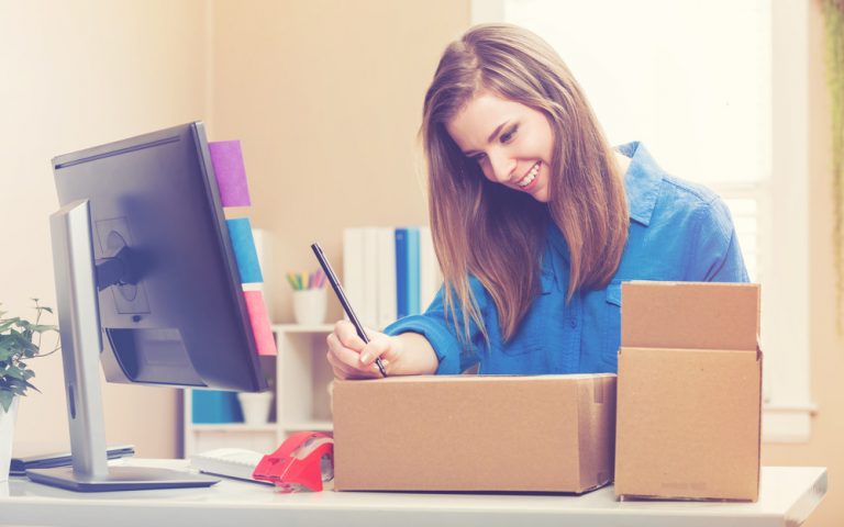 Young woman packing boxes to be shipped